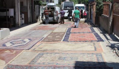 Asfaltlanmayan sokağın tozundan rahatsız olan mahalleli yola halı serdi